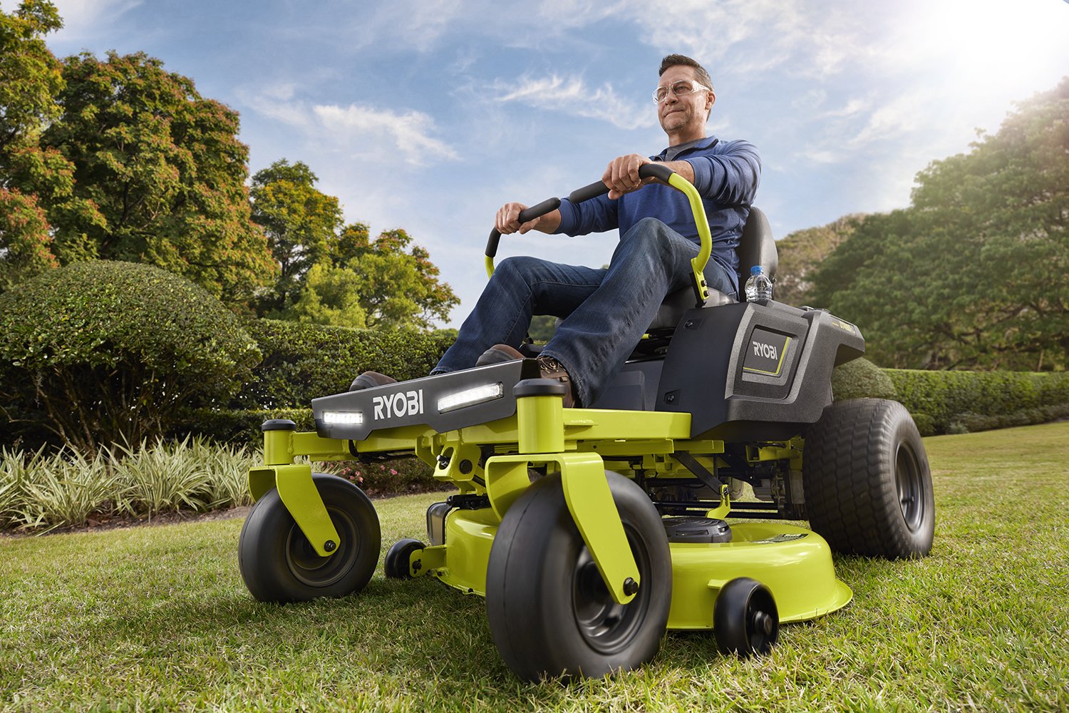 Man mowing lawn with Ryobi riding mower